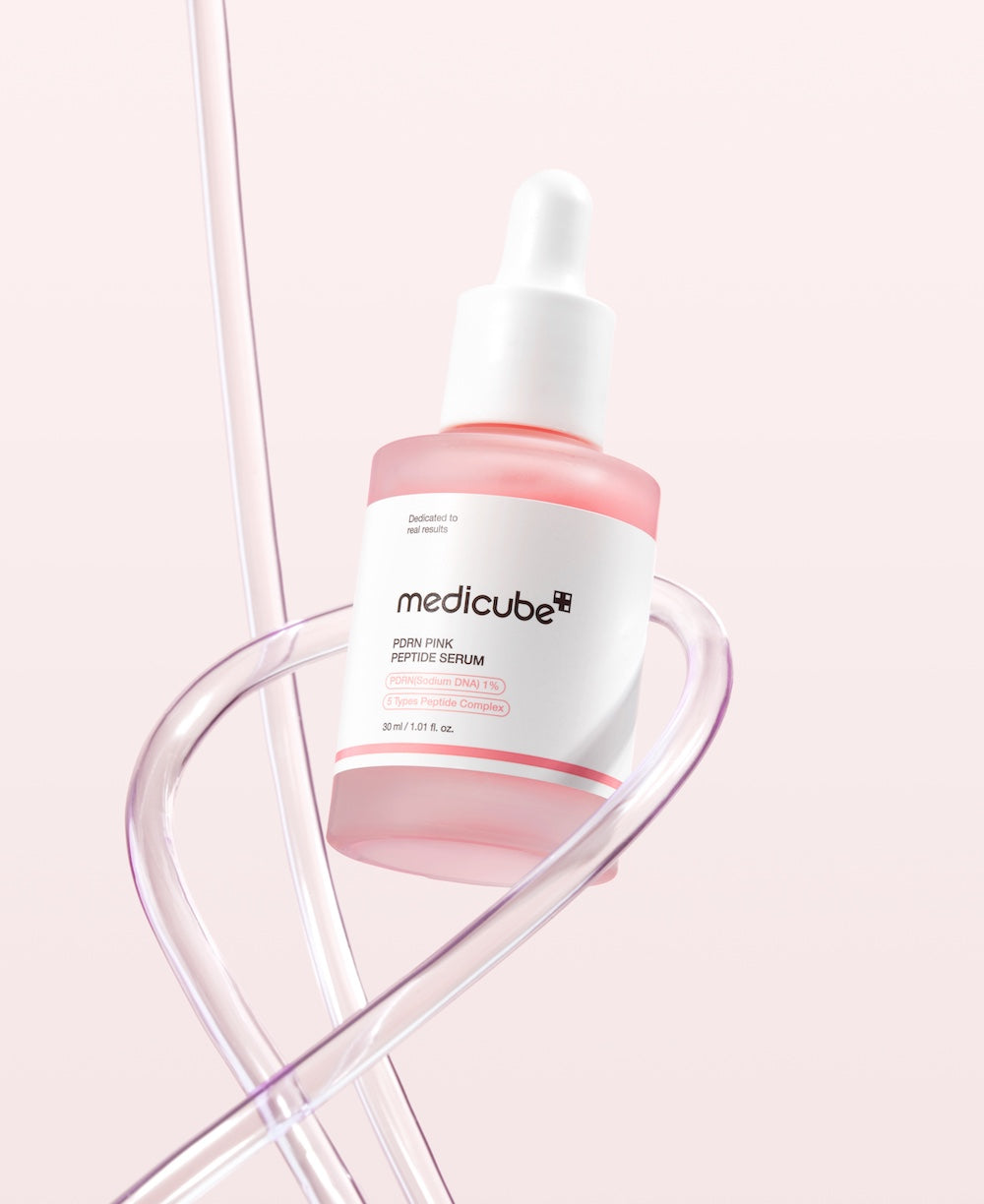 Medicube serum bottle on a pink background