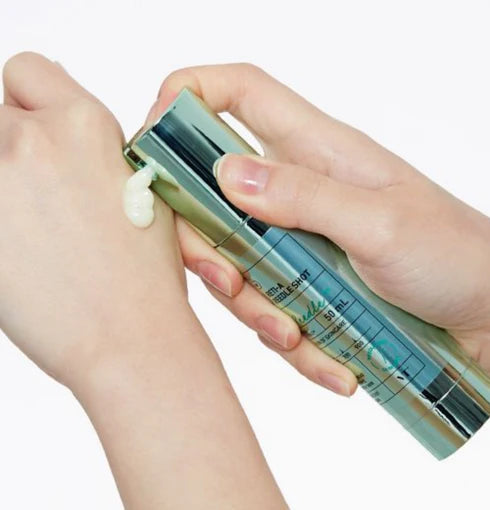 Hand holding a skincare product with a white background